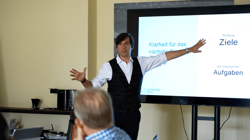 Coach präsentiert Ziele vor einer Gruppe von Unternehmern